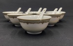 Inglaterra. Seis tigelas e 6 colheres em porcelana branca, esmaltado, rica decoração com brasão real britanico.Medindo: 5 x 11,5 cm e 12,5 cm. Uma tigela com bicado. 