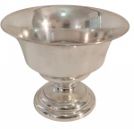 Pequena fruteira em metal espessurado a prata, de formato circular, corpo liso com borda evertida, apoiado sobre pedestal com base circular moldurada. Apresenta riscos superficiais e marcas do tempo. Medindo: 14 x 11 cm.
