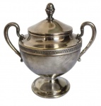 EBERLE.  Antigo açucareiro em metal espessurado a prata, corpo bojudo com faixa de motivos lanceolados em relevo, duas alças laterais curvas e base circular elevada. Tampa com puxador em forma de botão floral. Marca do fabricante e inscrição na base. Apresenta riscos superficiais, oxidação e desgaste. Medindo: 13 x 14 cm.