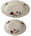 ?MIELÓW, Poland. Duas travessas em porcelana polonesa, decoração com rosas vermelhas e folhagens em policromia sobre fundo branco, bordas de contorno ondulado e filetes em ouro. Manufatura no verso. Medindo: 34x23 cm e 23x16 cm.