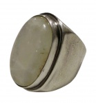 Anel vintage em prata teor 950, com aro largo e pedra oval em tom branco transparente, lapidada em cabochão e emoldurada por frisos lisos. Aro: 19. Peso: 15,7 g.