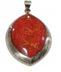 Antigo pingente em prata teor 925, de formato ovalado com extremidades afiladas, guarnecido por cabochão vermelho com veios alaranjados, em moldura larga de superfície escovada. Contraste no verso. Peso: 10,5 g. Medidas: 5 x 2,9 cm.
