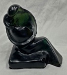 Escultura em resina decorativa de formas estilizadas, representando duas figuras abraçadas, com acabamento polido em tonalidade verde-escura e base irregular revestida de feltro.  Medidas: 25 x 23 x 17 cm.