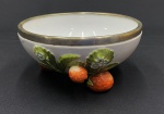 WMF. Centro de mesa em porcelana branca, com decoração policromada de morangos, folhas e flores em alto-relevo, apoiado sobre pés em forma de frutos. Borda com guarnição em metal espessurado à prata WMF. Apresenta marcas do tempo e desgaste na guarnição. Medidas: 10 x 21 cm.