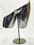 Luminária de mesa em metal, com cúpula escultórica assimétrica de superfícies curvas, haste vertical e base circular. Acabamento escurecido, com marcas de uso e desgaste. Funcionando. Medidas: 50 x 17 x 35 cm.