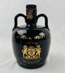 Royal Butt De Luxe Scotch Whisky. Antigo whisky escocês blended produzido pela The Glen Mist Company, com indicação de procedência de Londres e Leith, Escócia. Acondicionado em característica garrafa cerâmica esmaltada em preto brilhante, com alças laterais integradas ao corpo e decoração em dourado com brasão heráldico. Exemplar de apresentação diferenciada, bastante apreciado por colecionadores de garrafas e bebidas vintage, mantendo lacre aparente e conteúdo preservado no interior da garrafa opaca. Conteúdo não atestado. Tampa solta.