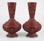 China. Imponente par de vaso em laca vermelha, ricamente ornamentado em alto-relevo com delicados motivos florais e arabescos, com corpo bojudo e pescoço alongado, Interior em azul contrastante, com etiqueta original de procedência. Medindo: 39 x 27 cm.