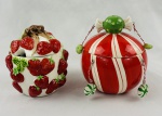 Dois potes com tampa em cerâmica esmaltada e policromada, sendo um decorado com morangos e folhas em relevo e outro de formato globular, com faixas vermelhas e brancas, puxador em forma de bala e pequenos pendentes decorativos.