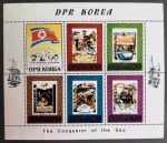 Coreia do Norte (DPR Korea), 1980 Mini-folha comemorativa da série `The Conqueror of the Sea` (Os Conquistadores do Mar) composta por 5 selos e uma vinheta temática dispostos em duas fileiras de três. O conjunto ilustra e homenageia grandes navegadores, exploradores e cientistas marítimos da história da humanidade: Fernando de Magalhães, Fridtjof Nansen, William Edward Parry, Jacques-Yves Cousteau e James Cook. A vinheta posicionada no canto superior esquerdo exibe a bandeira da Coreia do Norte acompanhada pelo retrato em perfil dos homenageados. As margens da folha são finamente ornamentadas com desenhos de caravelas clássicas. MINT