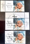 Alemanha, 2005  Lote com 3 selos comemorativos: Homenagem póstuma ao Papa João Paulo II (Michel #2460), lançado logo após o falecimento do pontífice. O design sóbrio e imponente combina um retrato fotográfico expressivo com o pictograma da cruz acompanhado das iniciais "TM". Este lote oferece uma oportunidade única de estudo filatélico, reunindo três variantes e estados da peça: um exemplar novo (MINT/MNH) com a desejada marcação de borda na margem esquerda; um raro exemplar com o carimbo oficial de primeiro dia de circulação (Erstausgabe Berlin, 12.05.2005); e outro circulado (sobre fragmento) com o carimbo postal de Helbra.