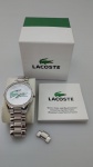 LACOSTE - Relógio original Lacoste com pulseira prateada e fundo do mostrador branco . Funcionando. Necessita trocar a bateria.