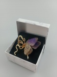 Belíssimo Broche em metal dourado, representando Borboleta e metade serpente , sendo serpente trabalhado em pedrinhas e  assas da borboleta revestido em tecido furta cor . Medindo : 5 x 4 cm