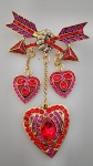 Exuberante Lindo broche em metal dourado representando FLECHA DE CORAÇÃO DE CUPIDO  , todo trabalhado em pedrinhas , nos tons vermelho e roxo . LINDA PEÇA .Medindo : 10x7 cm.