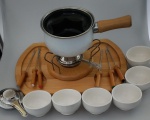 Conjunto para Fondue , sendo base em madeira giratória, panela e tampa em Ágata, com seis pega de madeira e seis recipiente em porcelana. Base medindo : 41x29x15 .
