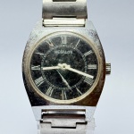 MEGALON - Relógio a corda, não funciona. Pulseira: 18mm. Caixa: 3,7cm x 3,7cm, vertical x horizontal, sem contar a coroa. ***ATENÇÃO! ESTE RELÓGIO NÃO POSSUI GARANTIA DE FUNCIONAMENTO. Produto sendo vendido conforme ESTADO, testado, ou não, diz respeito apenas ao momento da catalogação. Recomenda-se revisão.*** Se necessário, solicitar mais fotos, vídeos ou perguntas para análise via e-mail reidaantiguidade@gmail.com, Obrigado pela visita!