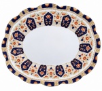 CROWN  Porcelana Inglesa, Circa 1900. Saladeira de formato ovalado com borda recortada, em porcelana inglesa, decorado ao estilo Imari, em rica composição de azul-cobalto, laranja, branco e dourado. Apresenta reservas florais, arabescos e elementos ornamentais distribuídos de forma simétrica, com delicada pintura à mão e filetes dourados. No verso, marca CROWN, sob coroa, com monograma W.L.L. Mede 28,5 x 23 cm.