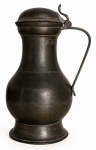JHON SOMERS - Jarra antiga em estanho, com corpo bojudo, tampa articulada, alça e base pedestal. Apresenta desgastes tempo na coloração. Possui marca da manufatura Jhon Somers na base e inscrições na lateral. Mede 24 cm x 15 cm.