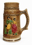 Caneca para chope em cerâmica, com decoração em relevo e policromada, apresentando figuras em trajes tradicionais e acabamento em esmalte marrom. Alça ornamentada. Marca da manufatura São Joaquim, Pedreira - SP na base. Mede 18,5 cm de altura.