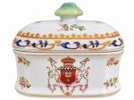 COMPANHIA DAS ÍNDIAS  Rara compoteira em porcelana Companhia das índias de formato retangular arredondado, com tampa e pega em tom verde translúcido. Rica decoração policromada com delicados motivos florais, ornamentos em azul e dourado e brasão central coroado, ladeado por cervos. Medidas: 13,5 x 10 cm.