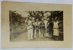 Foto Bilhete Postal Época (c. 1920/1930) Grupo Familiar  Papel Satrap AntigoBelíssimo e raro registro social em tom sépia, mostrando um numeroso grupo familiar posando ao ar livre em uma propriedade (possivelmente um sítio ou chácara da época). O grande destaque colecionável deste lote é a moda e os trajes típicos dos anos 1920/1930, evidenciados nos vestidos de corte reto, chapéus estilo cloché usados pelas mulheres e os trajes masculinos de época.