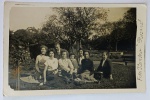 Foto Antiga Época (c. 1950) Grupo em Picnic com Identificação de Estúdio "Foto Roméro - Rozeral"Belíssimo registro social que captura um grupo composto por sete mulheres e um homem descontraídos, realizando um piquenique na grama de uma praça ou parque arborizado de época. É possível observar detalhes ricos do vestuário do período, como saias rodadas, blusas de manga longa listradas e penteados característicos dos anos 1950.