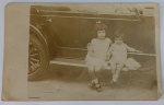 Foto Histórica Época (c. 1920/1930) Crianças no Estribo de Carro Antigo  Rodas de Raios de Madeira  Raro e belíssimo registro em tom sépia que une a temática infantil ao universo dos carros clássicos pioneiros. A imagem mostra duas crianças pequenas (um menino e uma menina) sentadas lado a lado diretamente sobre o longo estribo lateral de um automóvel antigo. Destaque Técnico Colecionável: O grande diferencial comercial deste lote é a riqueza de detalhes do veículo de época, evidenciando as rodas com raios de madeira aparentes (artillery wheels), o grande para-lama curvo e a estrutura das portas com trincos cromados mecânicos em formato de maçaneta clássica dos anos 20.