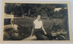 Foto Época (c. 1950) Jovem Sentada em Tronco à Beira de Lago com Ponte  Borda CanoaBelíssimo e descontraído retrato em preto e branco capturando uma jovem mulher posando ao ar livre. Ela está sentada sobre o tronco de uma árvore caída ou inclinada à beira de um lago ou espelho d'água.