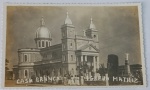 Foto Postal Datada (1953) Igreja Matriz de Casa Branca - SP com Longo Relato Familiar de Época  Borda Canoa Imponente e nítido registro arquitetônico da imponente Paróquia Nossa Senhora das Dores (Igreja Matriz de Casa Branca - SP). A cena destaca a monumental cúpula/zimbório, as duas torres sineiras sineiras, a fachada de linhas clássicas e o monumento com uma estátua de Cristo à direita. Em primeiro plano, vê-se pedestres caminhando e árvores com caules caiadosO verso é uma fascinante e íntima crônica do cotidiano familiar no interior paulista em 1953, enviada da cidade (abreviada como "Casa B.") para "Consuelo e Orlando". A remetente (assinada no canto inferior direito como "Dica") relata notícias médicas, festividades locais e o paradeiro de parentes