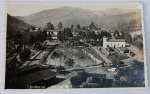 Foto Postal Palace Hotel Quisisana (c. 1951) Endereçado a Santos  Papel Wessel Antigo  Borda Canoa Amplo e detalhado registro panorâmico/aéreo do histórico complexo hoteleiro do Palace Hotel Quisisana em Poços de Caldas - MG, emoldurado pelas montanhas da região. Riquíssimos Detalhes do Verso (Transcrição Íntegra):O verso traz o layout clássico com a marca do fabricante na linha divisória e o preenchimento completo dos campos de correspondência, conectando a viagem em Minas Gerais à Baixada Santista: