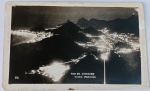 Foto Postal Noturna Época (c. 1950) Vista Panorâmica de Copacabana e Botafogo  Série 55Impressionante e clássico registro panorâmico noturno da Zona Sul do Rio de Janeiro - RJ, tomado a partir de uma grande elevação (provavelmente do Morro do Corcovado ou do Mirante Dona Marta)