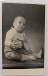 Retrato Fotográfico Vintage (1960)  Bebê "Henriquinho" (Porto Alegre - RS) com Assinatura de EstúdioLindo retrato fotográfico original de época, em formato cartão-postal vertical com charmosas bordas recortadas em estilo guilhotina (ziguezague). A imagem registra em plano inteiro o bebê Henriquinho sentado sobre uma superfície de madeira polida. Ele veste um conjunto de inverno de época em tricô claro (casaco com gola trabalhada e shorts), meias altas e sapatinhos de amarrar em couro claro.