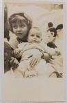 fotografia vintage original de família, provavelmente datada entre as décadas de 1940 e 1950, apresentando duas crianças e um boneco do Mickey Mouse ao fundo.Fotografia Antiga / Gelatina de Prata sobre Papel (Vintage Snapshot).