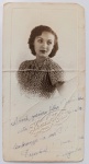   Retrato Feminino / Religião / Identificação Familiar de Santos. Retrato de estúdio em plano médio de busto de uma jovem senhora, com forte correlação ao eixo familiar de Santos (SP). Ela posa com o olhar direcionado para a lateral, exibindo moda e penteado clássicos da virada dos anos 1930 para 1940. Veste uma blusa texturizada ou estampada de mangas curtas. Inscrições e Carimbos: Apresenta carimbo em relevo seco original do "Foto Koechert - Santos" na parte frontal inferior. Rica dedicatória manuscrita à tinta azul que se inicia na frente (dedicada à "filha espiritual Jominha") e é finalizada no verso com a datação e localização em Águas de Lindóia. O verso traz ainda um carimbo oval esmaecido do fabricante do papel fotográfico.