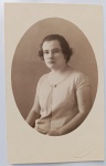   Retrato Feminino / Moda dos Anos 20 / Melindrosa / Identificado. Retrato de estúdio em plano médio de busto da jovem Othilia, posando com expressão serena. Ela exibe o corte de cabelo e trajes típicos da efervescência cultural e da moda jovem da década de 1920. Inscrições no Verso: Rica dedicatória manuscrita à tinta com caligrafia clássica e ortografia de época, assinada pela retratada ("Othilia"), direcionada à sua grande amiga "Maria Augusta". Datada de "10-4-926". Canto inferior direito do verso com um discreto carimbo circular esmaecido de fabricação do papel fotográfico.