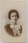   Retrato Feminino / Moda dos Anos 30 / Identificação Familiar / Círculo de Maria Augusta. Retrato de estúdio em plano médio de busto de três quartos da jovem Carmen, posando com semblante sereno e melancólico. Ela ostenta elementos estéticos marcantes da moda jovem de 1934, com destaque para o penteado de ondas esculpidas e o vestido de gola com laço contrastante. Inscrições na Frente: Rica dedicatória manuscrita à tinta preta no quadrante inferior direito da imagem: "À M. Augusta, com a minha estima e amizade. Carmen. Bahia, 5/1/34", direcionada à figura central do arquivo (Dona Maria Augusta).