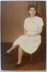  Retrato Feminino / Moda dos Anos 40 / Identificação Familiar / Eixo Rio de Janeiro. Retrato de estúdio em plano americano de uma jovem senhora sentada em cadeira clássica de época, exibindo trajes, calçados e penteado de alta costura e estética do final dos anos 30 e início dos anos 40. Características Físicas: Fotografia original em tom sépia/castanho de excelente definição e nitidez, textura de emulsão fosca. Formato de corte reto tradicional.