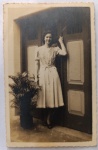   Retrato Feminino / Moda dos Anos 40 / Votos de Fim de Ano / Identificado. Retrato de corpo inteiro da jovem Hilda Estevam em Santos, posando junto a uma grande porta residencial e vaso de planta de época. Inscrições no Verso: Rica e completa dedicatória manuscrita à tinta escura, assinada pela retratada (Hilda Estevam), direcionada aos seus padrinhos Antonio e Sofia, contendo votos de Natal e Ano Novo (19401941). Caligrafia clássica perfeitamente preservada.