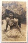   Retrato Feminino / Moda dos Anos 40 / Votos de Fim de Ano / Identificado. Retrato em plano inteiro da jovem Vautila Estevam, posando sentada em um jardim residencial cercada por palmeiras decorativas de época. Inscrições no Verso: Rica dedicatória manuscrita à tinta escura, assinada pela retratada (Vautila Estevam), direcionada aos seus padrinhos Antonio e Sofia, contendo votos de Natal e Ano Novo (19401941). Caligrafia clássica impecavelmente preservada.