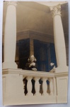  Fotografia Antiga / Fotografia Vernacular de Viagem Internacional (Real Photo Snapshot). Data Exata: 1949 (Final da década de 1940 / Pós-Guerra). Procedência Geográfica: Cape Town (Cidade do Cabo), África do Sul. Tema: Retrato Feminino / Turismo Internacional / Arquitetura Clássica / Família Oliveira Develly. Retrato em plano médio da jovem Odette Oliveira Develly posando sorridente na varanda de um palacete colonial em Cape Town, emoldurada por colunas coríntias e balaustrada.