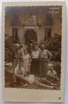  Fotografia Antiga / Cartão-Postal Fotográfico Vernacular de Viagem (Real Photo Postcard - RPPC). Época Estimada: Circa 19451955. Procedência Geográfica: Poços de Caldas, Minas Gerais. Marco Histórico: Monumento ao Dr. Pedro Sanches de Lemos ("Sciencia e Bondade"). Tema: Retrato de Família / Turismo Nacional / Estâncias Hidrominerais / Moda dos Anos 40 e 50 / Identificado. Retrato formal em ambiente externo de um grupo de sete familiares posando no jardim público de Poços de Caldas, exibindo trajes civis de passeio e de veraneio da época.