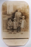  Fotografia Antiga / Cartão-Postal Fotográfico de Estúdio Externo (Real Photo Postcard - RPPC). Data Exata: 06/08/1928 (Anos Loucos). Procedência: São Paulo - SP (Núcleo Paulista). Tema: Retrato de Família / Maternidade / Infância / Moda dos Anos 20 / Chapéu Cloche / Totalmente Identificado. Retrato de corpo inteiro da mãe Casilda com seus filhos Aglaé, Isolda e Carlos Arthur posando em um parque público de São Paulo. Inscrições no Verso: Rica e completa dedicatória manuscrita à tinta escura, assinada pela remetente, direcionada aos irmãos Alarico e Beatriz. Linha divisória com a tradicional marca de papel postal "WESSEL". Formato de cartão com cantos cortados em padrão octogonal de época.