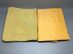 CAMA - MESA - BANHO - Lote composto por duas toalhas de mesa em tons monocromáticos de amarelo/dourado, medindo aproximadamente 300 cm x 150 cm cada. As peças apresentam textura levemente acetinada com padronagem de listras finas verticais, conferindo um aspecto sóbrio e versátil para a composição de mesas. Em bom estado de conservação, ideais para propostas que buscam luminosidade e elegância clássica. Marcas do tempo e de uso.