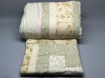 CAMA - MESA - BANHO - Conjunto em técnica patchwork de solteiro, composto por colcha matelassada e uma fronha coordenada. Confeccionado em tecidos de algodão com padronagens variadas em tons suaves de verde, bege, rosa e off-white, combinando florais miúdos, listras e poás. Marcas do tempo e de uso.