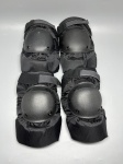 DIVERSOS - Conjunto de quatro peças de proteção (dois pares de joelheiras/cotoveleiras táticas ou esportivas), em tecido sintético preto de alta resistência, com conchas rígidas de proteção frontal em plástico moldado fixadas por rebites. Possuem tiras elásticas ajustáveis com fechamento em velcro. Apresentam desgastes normais de uso, leves marcas do tempo e pequenos desfiados.