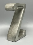 DIVERSOS - LETRA "Z" DECORATIVA EM ALUMÍNIO - Escultura decorativa em alumínio com acabamento prateado envelhecido, moldada no formato da letra "Z" com design robusto e linhas arredondadas. Medindo 15 cm de altura por 10 cm de largura e 4 cm de profundidade, é uma peça versátil e moderna, ideal para decoração de interiores, apoio de livros (bookend) ou colecionismo. Vendida no estado, sem garantia.