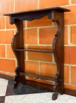 MOBILIÁRIO - Pequena estante de apoio ou consola de parede em madeira escura, estruturada em duas prateleiras horizontais com abas laterais recortadas em curvas elegantes e saias com recortes decorativos. Dimensões aproximadas: 90 cm (altura) x 75 cm (largura) x 24 cm (profundidade). <br><br>Móveis Usados - Lote de móvel antigo e usado, podendo apresentar marcas de uso e desgaste natural do tempo. Há possibilidade de danos ocultos e ou outras imperfeições. Não há garantia ou possibilidade de devolução após a aquisição. Recomenda-se inspeção prévia.