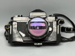 COLECIONISMO - FOTOGRAFIA E COLECIONISMO - Câmera analógica SLR Nikkormat (acabamento na cor preta), corpo em metal robusto, acoplada com objetiva Nikkor-H Auto 50mm. Acompanha estojo / capa rígida em couro original (case) com alça de transporte e etiqueta de identificação de viagem da época. <br><br>Colecionismo e Antiguidades - Lote de peça antiga e usada, apresentando marcas do tempo, desgastes no acabamento externo, poeira e oxidação natural nos componentes metálicos. O estojo de couro apresenta rachaduras e desgastes acentuados devido à idade. Equipamento mecânico sem garantia de funcionamento pleno, recomendando-se revisão técnica especializada ou inspeção prévia.