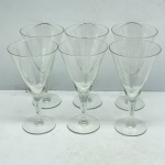 DEMI CRISTAL - Lote com Seis Taças em Demi Cristal Transparente Trabalhado com Lapidação de Folhagens/Ramos - Conjunto composto por seis taças em demi cristal transparente de cálice cônico, haste delicada e base circular plana. O bojo é finamente decorado com lapidação em relevo (fosca) formando motivos que remetem a ramos ou folhas dispostos simetricamente, complementados por finas linhas horizontais gravadas na parte inferior.