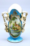 PORCELANA VIEUX PARIS - Vaso floreira em fina porcelana vitrificada, branca, decorada com relevo de flores na parte frontal, na cor azul e cena de paisagem em policromia e douração. Med. 24x17x10 cm. Marcas do tempo.