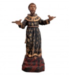 SÃO FRANCISCO DE ASSIS  Escultura em madeira policromada em vibrante ouro, representado com os braços abertos e pássaros nas mãos, sobre base decorada. Trabalho de caráter sacro, com pintura em preto e dourado. Minas séc. XIX. Mede 28 cm.